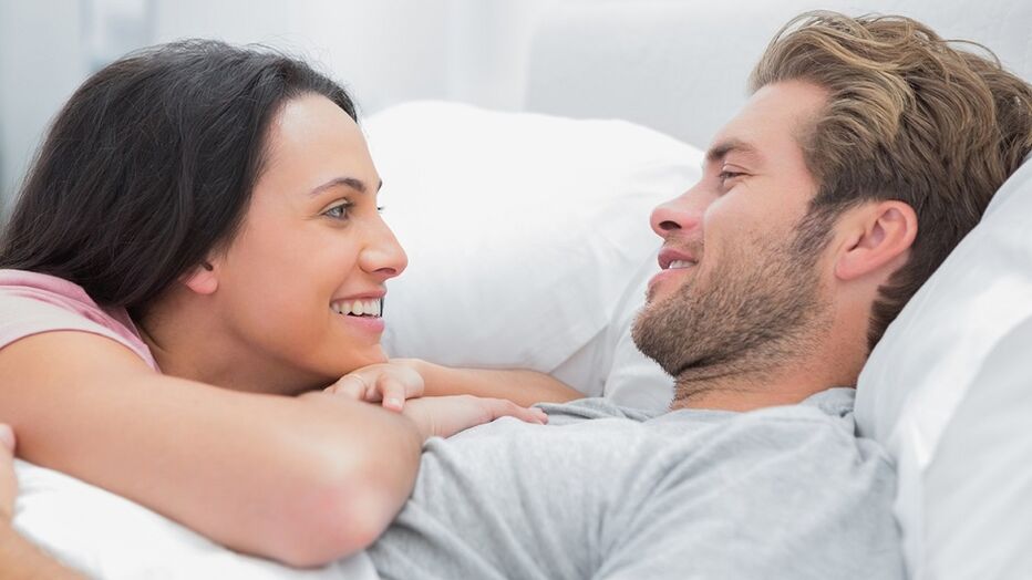 Happy woman with husband in bed